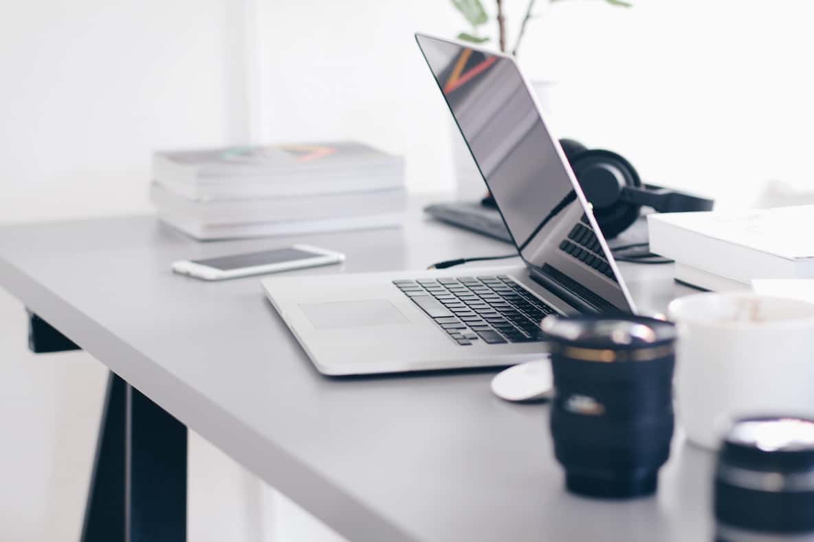 Offering Online Services and Classes. Picture of laptop and phone on top of desk.
