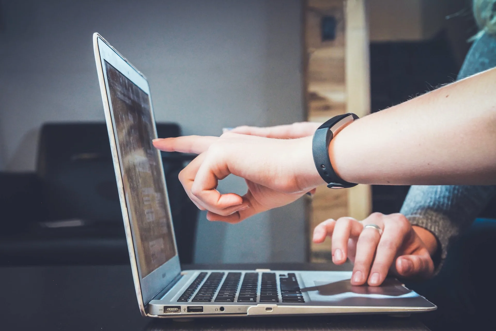 Person pointing to a laptop screen 