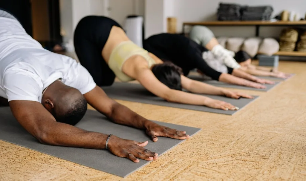 People in a fitness class stretching out on yoga mats