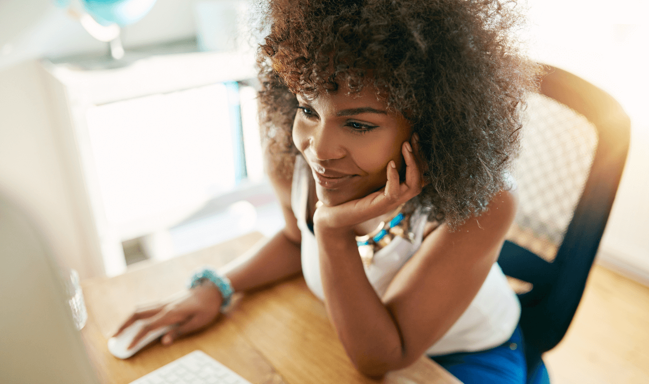 Woman sitting at a table on her computer implementing local SEO strategies